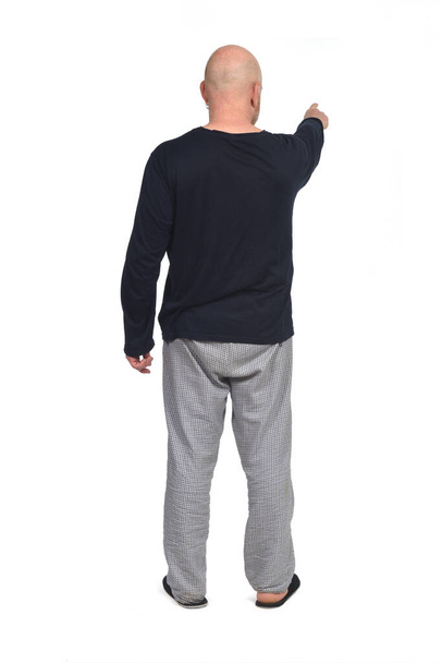 πίσω όψη ενός άνδρα με πιτζάμες χέρια που δείχνουν σε λευκό φόντο - Φωτογραφία, εικόνα
