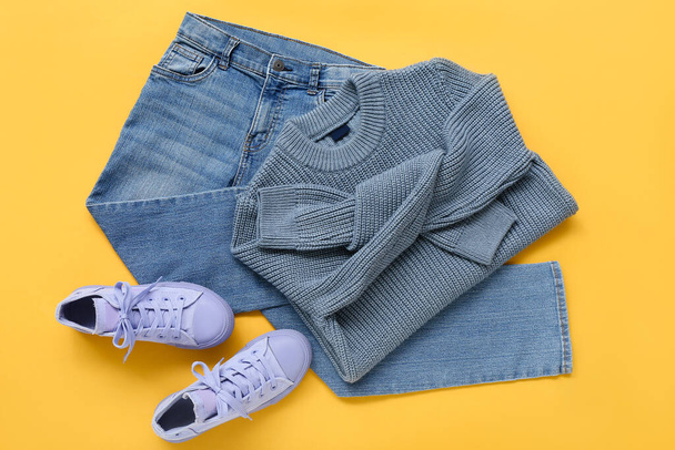 Suéter para niños con estilo, jeans y zapatos de goma sobre fondo de color - Foto, Imagen