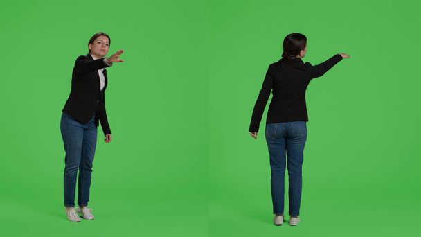 Office accountant advertising wave to call someone over, asking for person to come in studio. Female manager in suit raising hand standing over full body isolated greenscreen background. - Fotó, kép