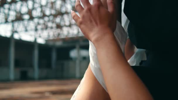ein asiatischer Mann hält und berührt den Körper einer Person, die am Nachmittag in einem leeren Gebäude an seiner Hand hängt - Filmmaterial, Video