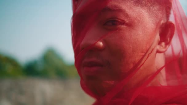 обличчя азіатського чоловіка, загорнутого в червоний шарф з розлюченим виразом вдень - Кадри, відео