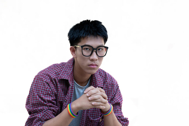 jong aziatische tiener in geruite shirt draagt regenboog polsbandjes en bril geïsoleerd op witte achtergrond met clipping paden. - Foto, afbeelding