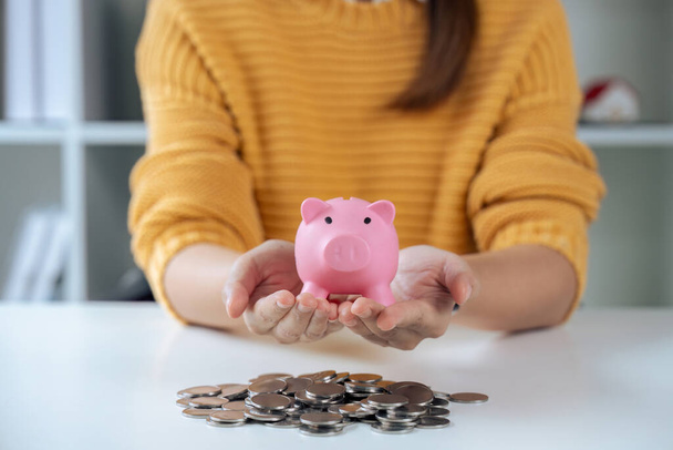 Frau hält Sparschwein, um Geld zu sparen, um Vermögen zu sparen und Münzen zu haben. Geld sparen. - Foto, Bild
