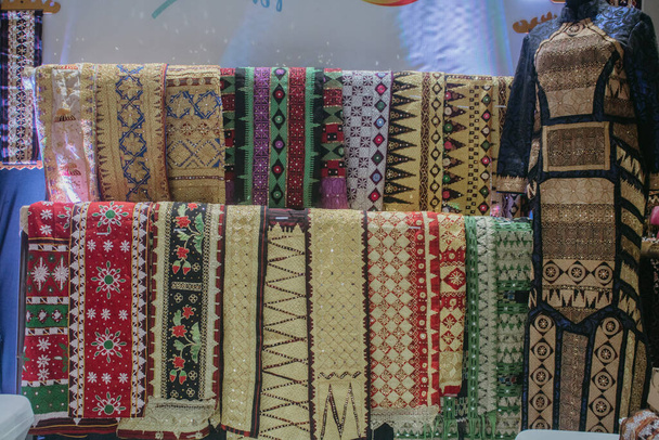 Tkanina Różne motywy. różne tkaniny wyświetlane na półkach. tkaniny, którą można nazwać typową tkaniną tapisową z prowincji Lampung w Indonezji. - Zdjęcie, obraz