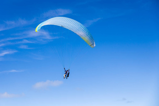 Parapente contra um fundo de céu azul acima de Granville - Foto, Imagem