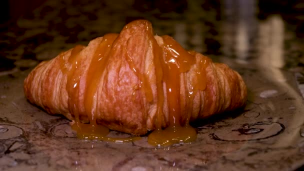 Croissant recién horneado con caramelo líquido en el interior cortado a la mitad aislado sobre fondo blanco. Delicioso croissant francés apilado - Imágenes, Vídeo