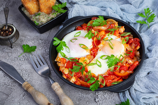 Shakshuka mit gegrilltem Brot. Gebratene Eier mit Tomaten, Paprika, Knoblauch und Kräutern - Foto, Bild