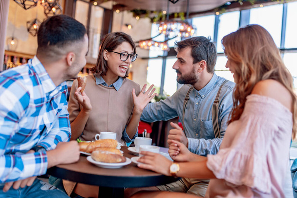 Eine Gruppe glücklicher Freunde frühstückt und trinkt Kaffee im Restaurant. Menschen, Freizeit, Freundschaft und Glückskonzept. - Foto, Bild
