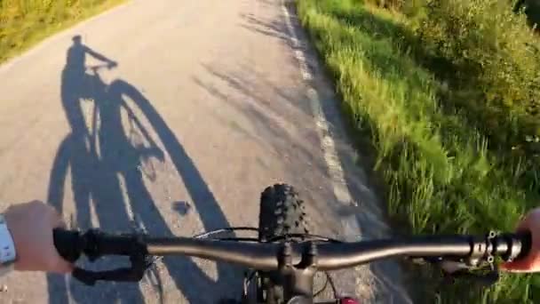 Žena středního věku na kole na slunné venkovské silnici - Záběry, video