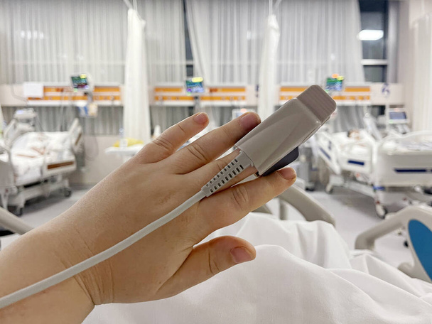 Dans l'hôpital malade patient sur le lit. Équipement de moniteur de fréquence cardiaque est sur son doigt, main gros plan - Photo, image