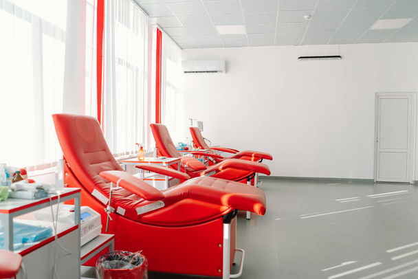 Bağış merkezinde oturmak için kırmızı koltuklar. Kan nakli istasyonu bağışçılardan kan almak için. - Fotoğraf, Görsel