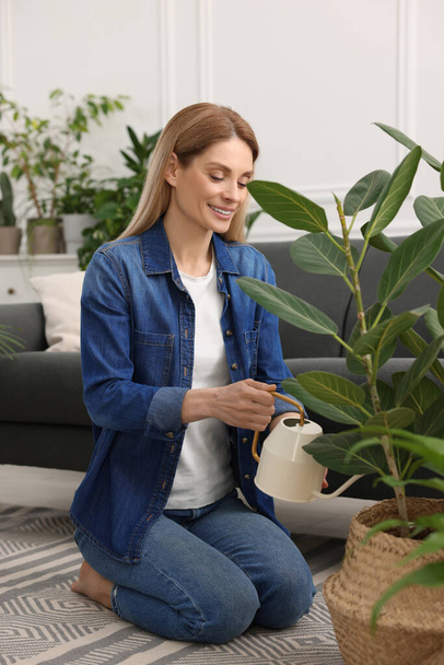 Woman watering beautiful potted houseplants at home - Foto, immagini