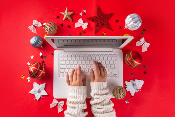 Fond de Noël Nouvel An avec clavier d'ordinateur portable blanc et décor de vacances d'hiver, ornements, sur fond rouge vif. Achats en ligne de Noël, préparation pour les vacances, espace de copie vue du dessus - Photo, image