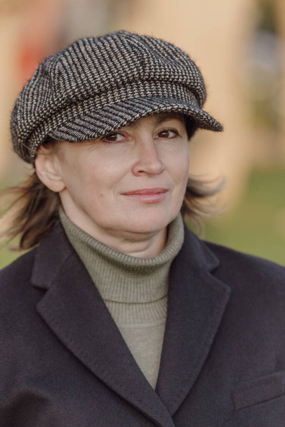 Μέση ηλικία γυναίκα σε ζεστό παλτό και καπέλο σε εξωτερικούς χώρους - Φωτογραφία, εικόνα