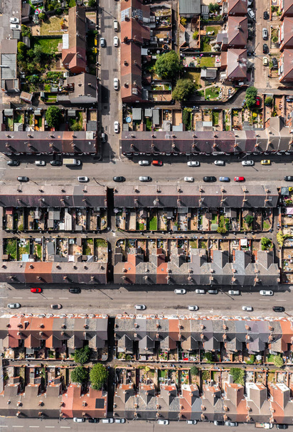 Вид с воздуха прямо над крышами рядов домов с террасами с переулками и садами в рабочей зоне северного города в Англии - Фото, изображение