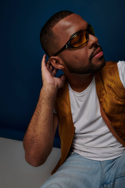 close up african american man in sunglasses on dark blue backdrop looking away, fashion concept - Photo, Image