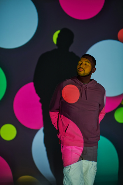 trendy african american male model with closed eyes in digital projector lights, fashion concept - Photo, Image