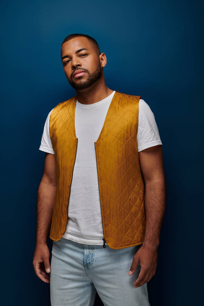 jovem modelo masculino afro-americano com barba e brinco em colete amarelo na moda, conceito de moda - Foto, Imagem