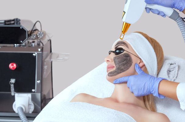 Procédure d'épluchage du visage en carbone dans un salon de beauté. Matériel traitement de cosmétologie. - Photo, image