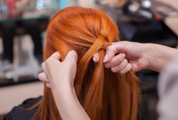 美しい赤毛の女の子,美容師は美容院でフランスのブレードのクローズアップを織ります. プロのヘアケアとヘアスタイルの作成. - 写真・画像