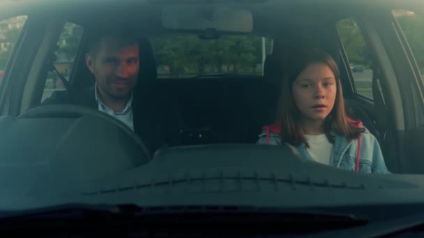 Dziecko cute dziewczyna wsiada do samochodu i za pomocą pasów bezpieczeństwa podczas podróży do weekendów z ojcem. Prawy samochód. Styl życia, rodzina, podróże, koncepcja rodzicielstwa. Czas rzeczywisty - Materiał filmowy, wideo