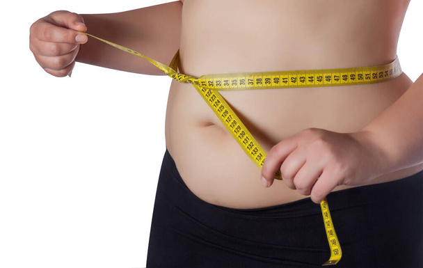 Mujer gorda midiendo su cintura con una cinta métrica amarilla. Reducción del sobrepeso y tratamiento de la obesidad. Estilo de vida saludable
. - Foto, Imagen