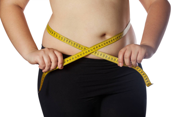 Λίπος γυναίκα μέτρηση της μέσης με μια κίτρινη ταινία μέτρησης. Μείωση του υπερβολικού βάρους και παχυσαρκίας θεραπεία. Υγιεινός τρόπος ζωής. - Φωτογραφία, εικόνα
