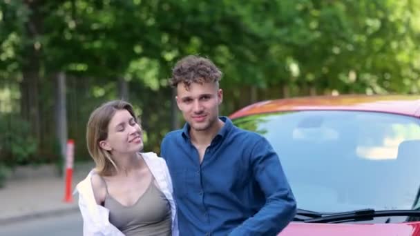 Usmívající se pár kupující nové auto, objímající a ukazující klíč z jejich nového auta. Rozumím. Životní styl, prodej, dopravní koncept. Reálný čas - Záběry, video