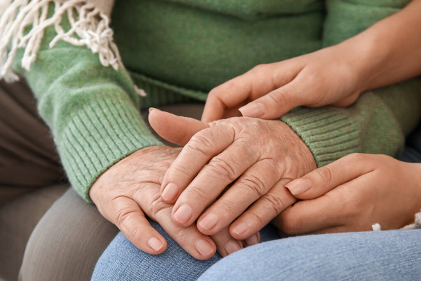 Starsza kobieta z wnuczką trzymającą się za ręce w domu, zbliżenie - Zdjęcie, obraz