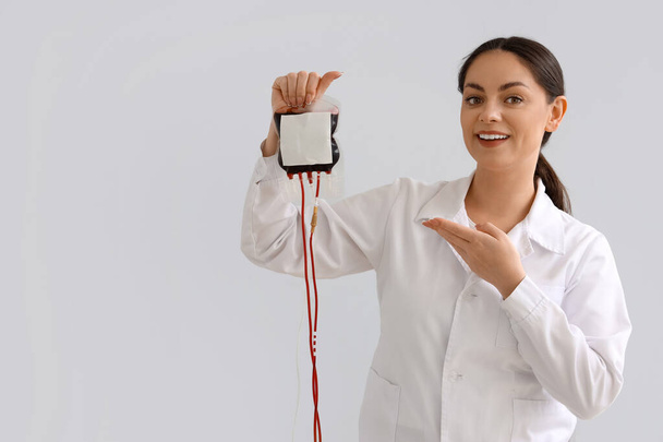 Médecin femelle pointant vers le groupe sanguin pour transfusion sur fond clair - Photo, image