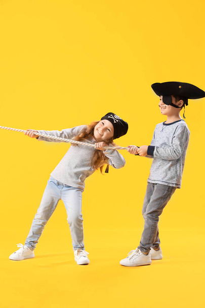 Χαριτωμένοι μικροί πειρατές με σχοινί σε κίτρινο φόντο - Φωτογραφία, εικόνα