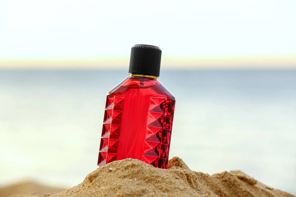 Eine Flasche Luxus-Parfüm am Strand Sand in der Nähe des Ozeans - Foto, Bild