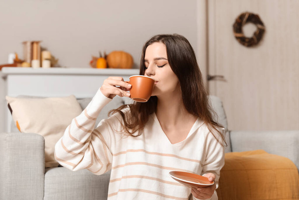 Молода жінка п'є гарячий чай вдома
 - Фото, зображення