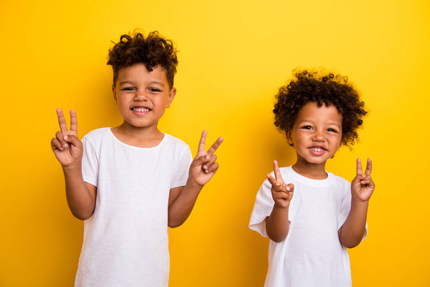 Photo of two funky friendly people toothy smile good mood demonstrate v-sign isolated on yellow color background. - Foto, Bild