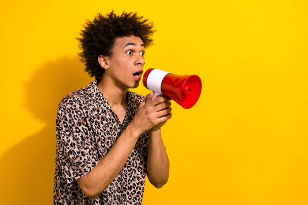 Photo of impressed funny guy dressed leopard shirt hold megaphone astonished staring at empty space isolated on yellow color background. - Photo, Image
