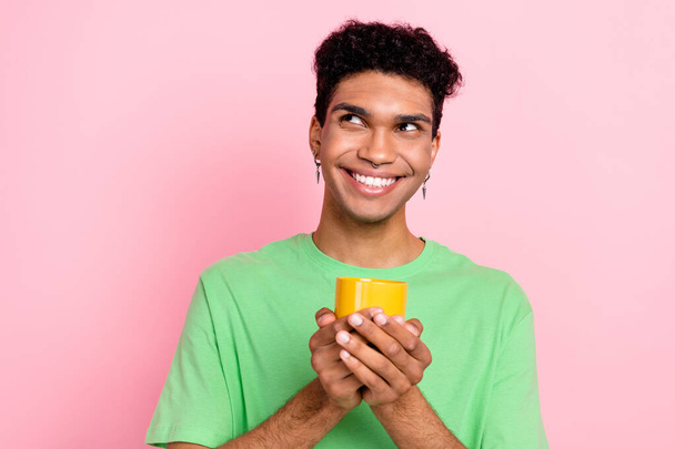 Photo of cheerful nice man wear green clothes old mug tasty tea look up adv empty space isolated on pink color background. - Foto, Bild