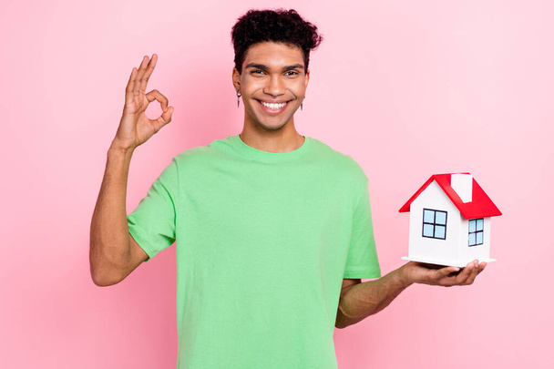 Photo of cheerful satisfied man wear trendy green clothes buy new flat apartment rent room okey sign isolated on pink color background. - Foto, immagini