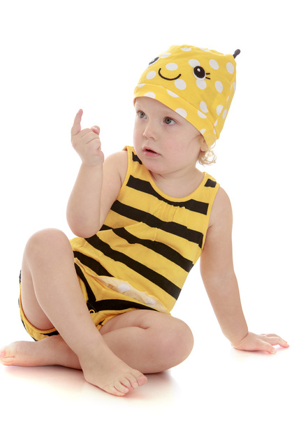 bardzo mała dziewczynka w Pszczoła prążkowany garnitur, siedząc na podłodze - Zdjęcie, obraz
