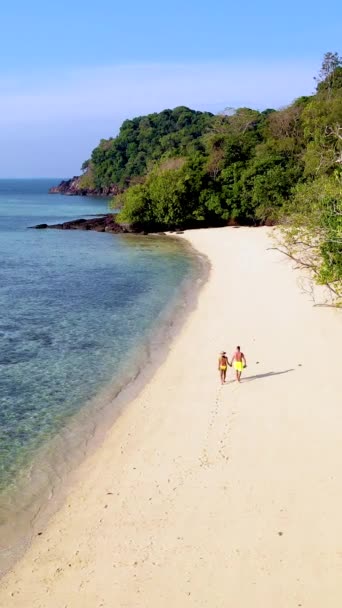 drone vista de cima na praia de Koh Kradan ilha na Tailândia, um casal diversificado de homens europeus e mulheres asiáticas em férias na Tailândia - Filmagem, Vídeo