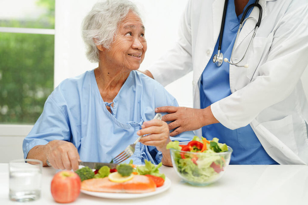 Asiatico anziana donna paziente mangiare salmone paletto e verdura insalata per sano cibo in ospedale. - Foto, immagini