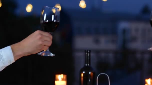 Gelukkige man en vrouw genieten van de datum op het terras in de avond tijdens het toasten met wijn. Romantisch afspraakje op het dak. Romantisch concept. Een paar verliefd. Real time - Video