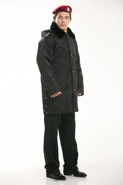 Δημιουργήστε όλων των ειδών τα ρούχα εργασίας αστυνομικός στέκεται μπροστά από ένα λευκό φόντο - Φωτογραφία, εικόνα