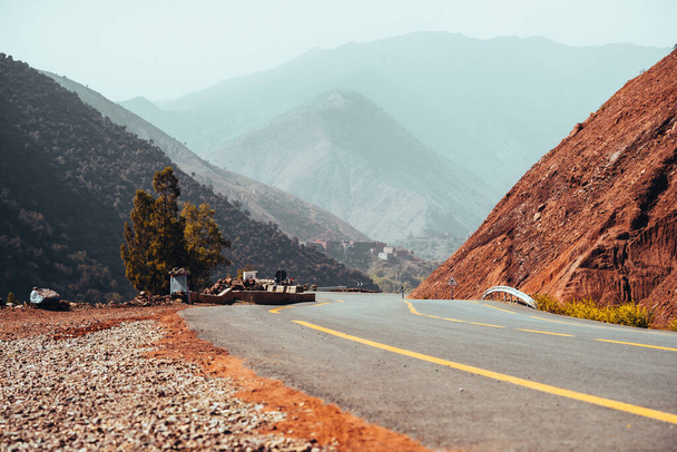 Carreteras sinuosas a través de las montañas del Atlas en Marruecos con una sola persona caminando. Foto de alta calidad - Foto, imagen