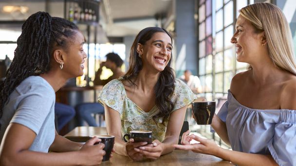 Multi-Cultural Group Of Female Friends Meeting And Catching Up In Restaurant Or Coffee Shop - 写真・画像