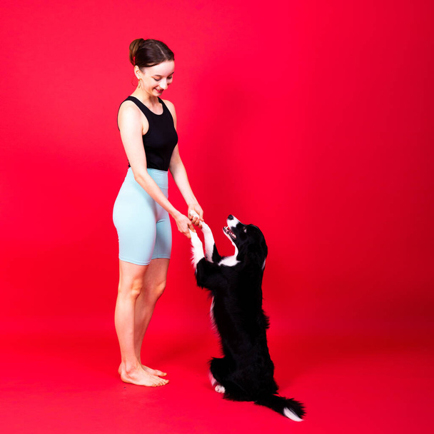 Mujer caucásica entrenando a un perro collie fronterizo. Concepto de relación entre humano y animal. - Foto, imagen