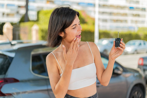 Young pretty Bulgarian woman holding car keys at outdoors with surprise and shocked facial expression - Photo, Image