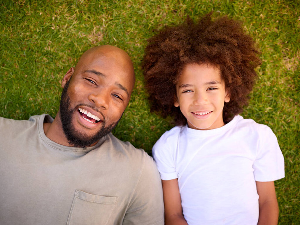 Overhead Shot Of Loving Father And Son Lying On Grass Together - Photo, image