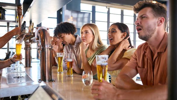 Disappointed Multi-Cultural Group Of Friends In Sports Bar Watching Team Lose Game On TV - Фото, изображение