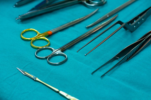 Ostrze chirurgiczne i grupa narzędzi chirurgicznych na stole operacyjnym. - Zdjęcie, obraz