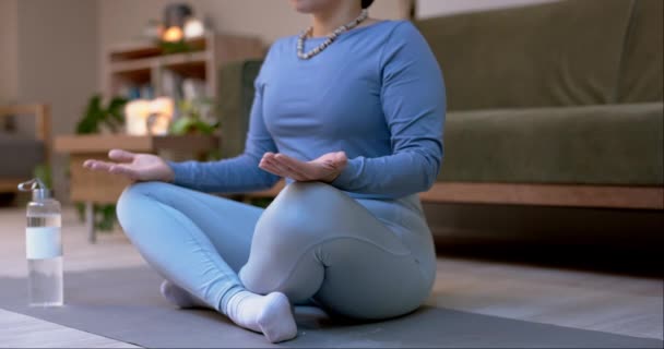 Lootuksessa meditoiva keho, jooga tai nainen aiheuttaa zen-rauhan tai mindfulnessin kotistudiossa. Chakra, lähikuva tai terve tyttö hengitys liikunnan harjoitus henkistä hyvinvointia tai koulutusta rentoutua. - Materiaali, video